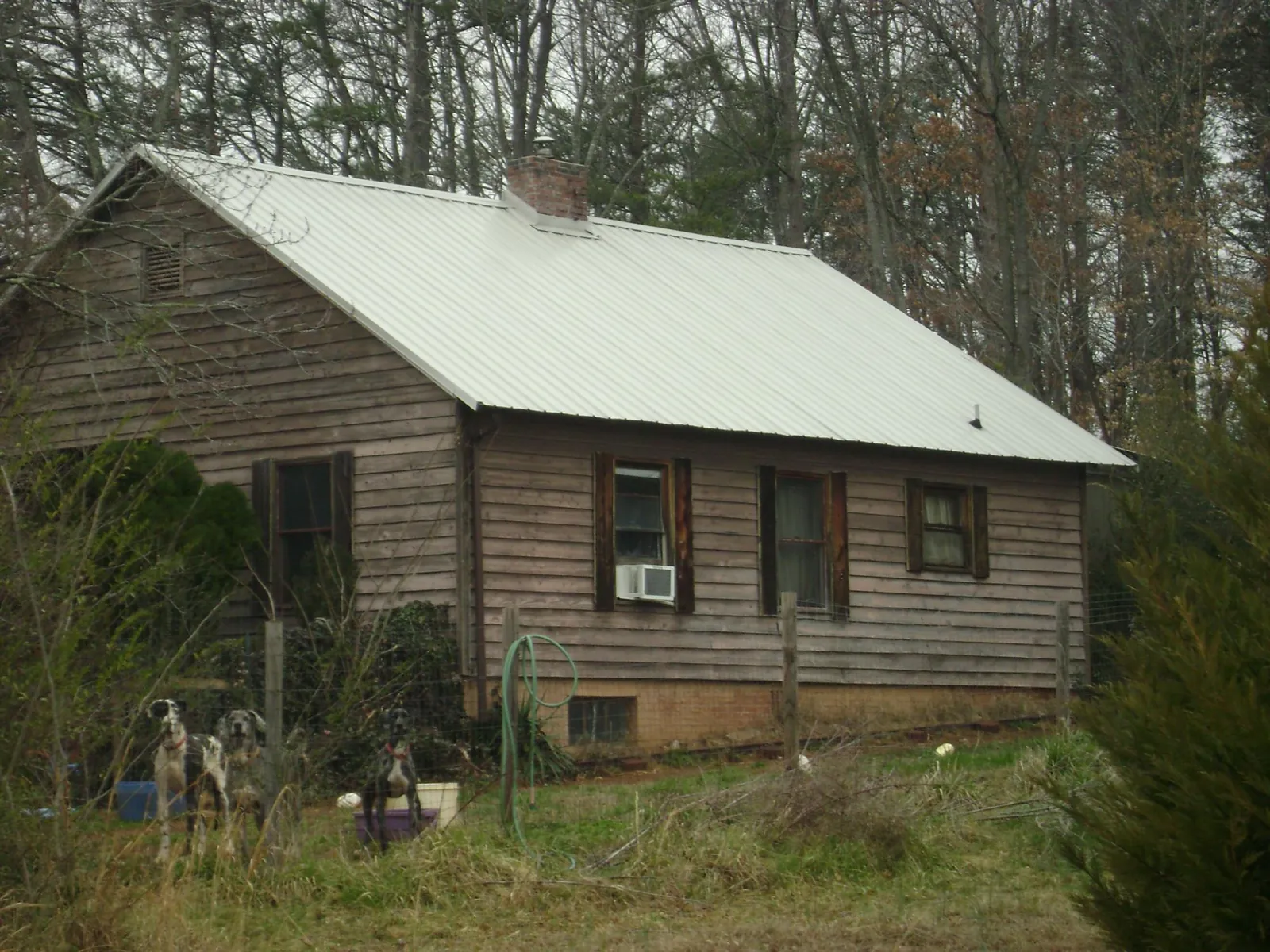 White metal roof on an old wood sided farmhouse, from a Metal Roof Installation job in Osyka